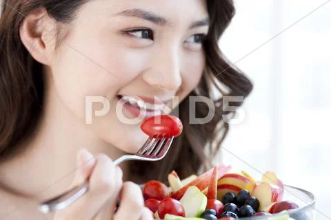 Young Woman Eating Fruit Salad