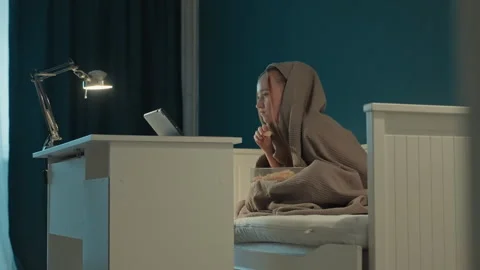 Young Woman Eating Snacks While Using Tablet On Bed In Bedroom With Teal Walls Stock Footage 345675090