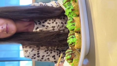 Young woman eats baked rolls with wooden chopsticks in cafe. Vertical video Stock Footage 264964085