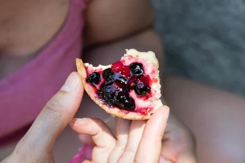A young woman eats a cake with fruit Stock Photos