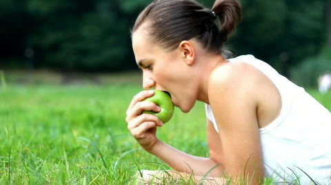 Young woman eats fresh apple outdoor Stock Footage