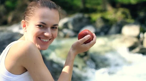 Young woman eats fresh apple, outdoors Video stock 7907765