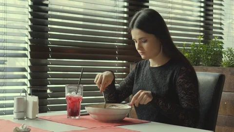 The young woman eats spaggeta paste in cafe. The lonely girl eats at restaurant. Stock Footage 86492194
