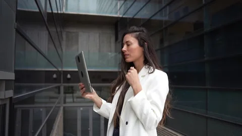 A Young Woman Engaged in Using a Tablet While in an Urban Setting Surrounded by Stock Footage 312609724