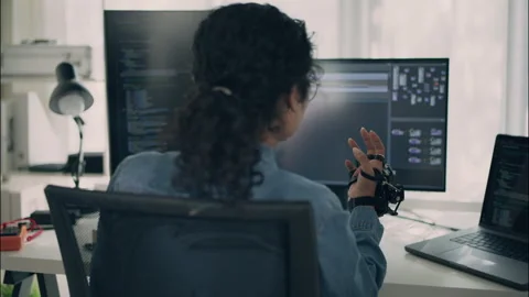 Young woman engineer testing robotic glove controller with coding. Stock Footage 319001522