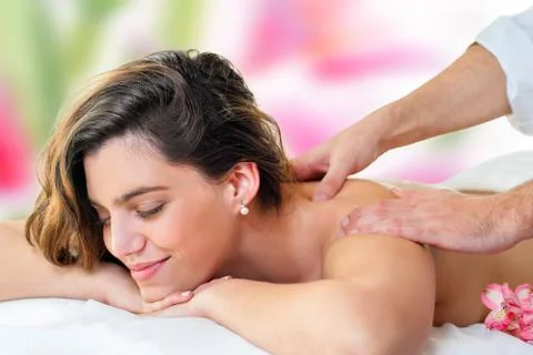 Young woman enjoying back massage. Stock Photos