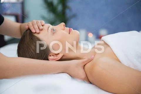 Young woman enjoying face and collar area massage Stock Photos
