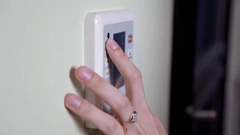 Young woman entering authorization code pin on home alarm keypad. Home security Stock Footage 101208944