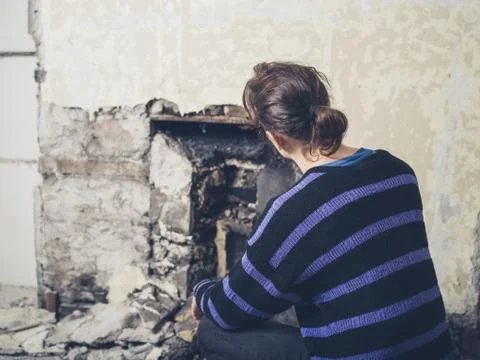 Young woman examinig fireplace Stock Photos