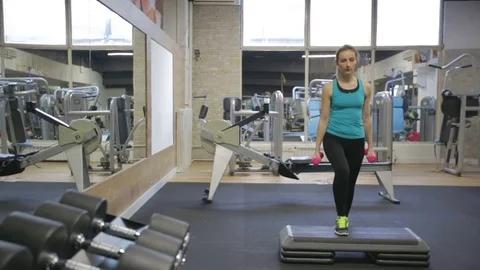 Young woman exercise step-ups with dumbbells, camera slider Stock Footage 71609720