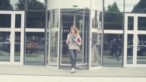 A young woman exiting from a shop door Stock Footage