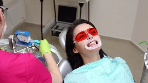 Young woman with an expander in mouth at the dental clinic. Application of Stock Footage