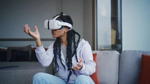 Young woman experiences virtual reality in living room while wearing VR headset  Stock Footage 339035641