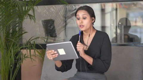 Young woman explaining something in a video call on her tablet. Vídeo Stock 146301031