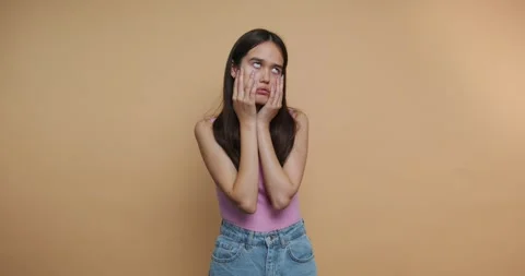 Young woman expresses different emotions in front of a plain background in .. Stock-Footage 328247053