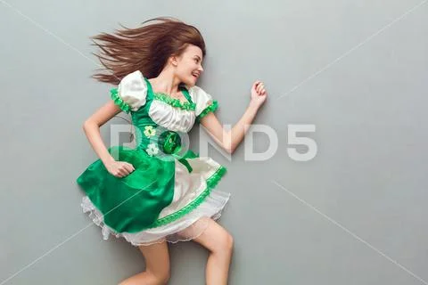 Young woman in a festive dress saint patrick's day top view running away Stock Photos
