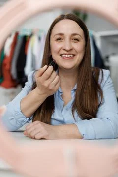 Young woman filming makeup tutorial in front of camera at home. Blogging And 스톡 사진