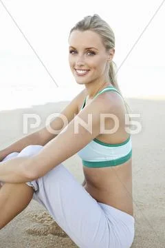Young Woman In Fitness Clothing Resting After Exercise On Beach Stock Photos