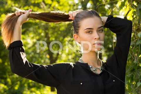 Young woman fixing her hair Stock Photos
