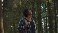 Young Woman In A Flannel Looking Out Into The Trees On A Hike Stock Footage