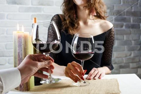 Young woman is flirting on a blind date with a man in a restaurant. The coupl Stock Photos