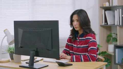 Young woman focused on computer screen sitting at wooden desk in modern bri.. Stock Footage 344917713