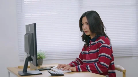 Young woman focused on computer screen working at desk in modern bright off.. Stock Footage 344917900