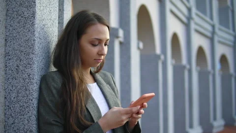 Young woman focused using smartphone, typing important email or checking an app Stock Footage 153106512