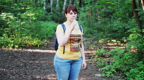 Young Woman in the Forest With a Backpack Drinking From a Bottle Stock Footage 63466178