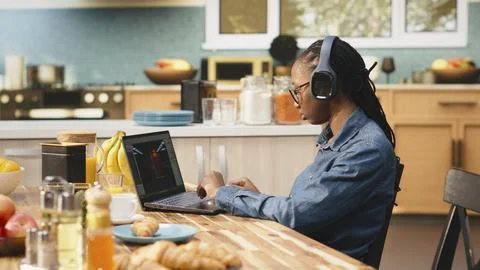 Young woman game developer with headset operates interactive gaming software Fotos Stock