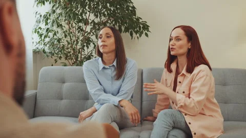 Young woman gesturing and explaining problems during therapy session Stock Footage 336851573