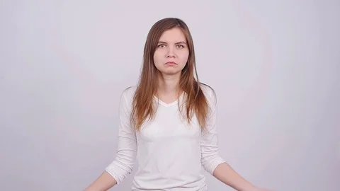 Young woman gesturing do not know sign against grey background Stock Footage 82012807