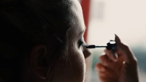 Young woman gets make-up. Apply the mascara on the eyelashes. Stock Footage 97614832