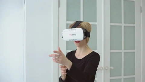 Young woman getting experience using VR headset glasses of virtual reality at Stock Footage 86460913