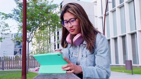 Young Woman with Glasses Using Tablet Outdoors Stock Footage 295516901