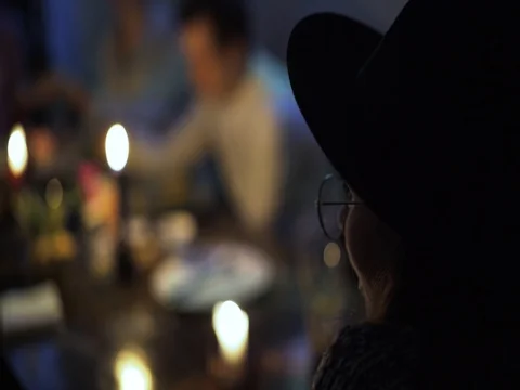 Young woman in a hat and glasses looking at people in restaurant Stock Footage 76718853