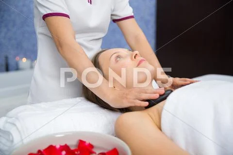 Young woman having chest stone massage in spa Stock Photos