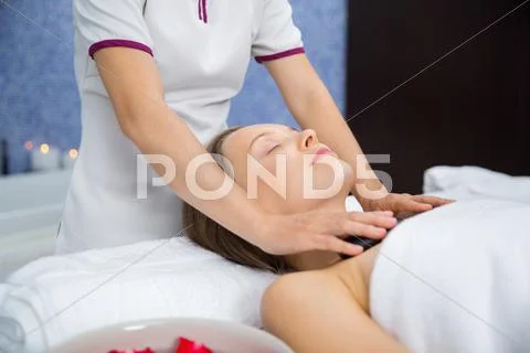 Young woman having chest stone therapy in spa Stock Photos