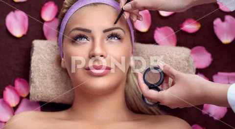 Young woman having the final touches of make up Stock Photos