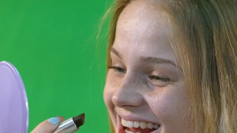 Young Woman Having Fun While Putting Red Lipstick On Stock Footage 97650658