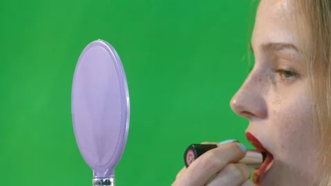 Young Woman Having Fun While Putting Red Lipstick On Stock Footage 97651036