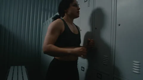 Young Woman Having Panic Attack in Modern Gym Locker Room Stock Footage 335398580