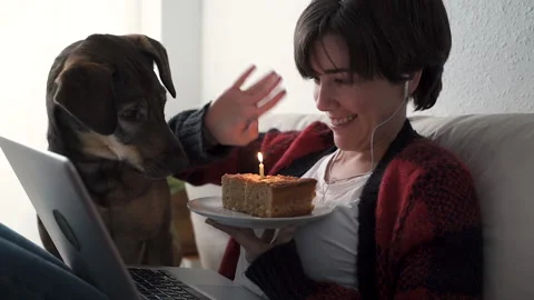Young woman having video call birthday party at home with her dog - Love care Stock Footage 143345053