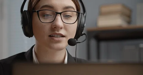 Young woman in headset supporting client during phone call Stock Footage 123561473