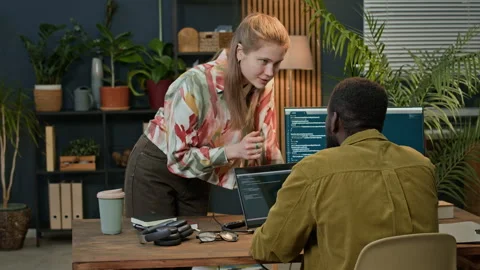 Young Woman Helping Colleague Developing Code on Laptop Video stock 302889900