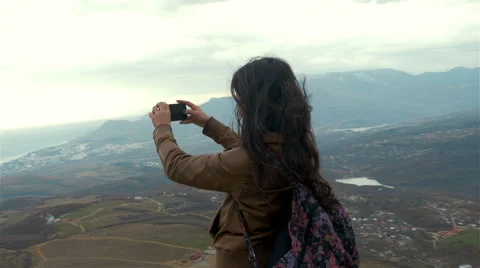 Young woman hiker taking photo with smart phone at mountain peak Video stock 59082948