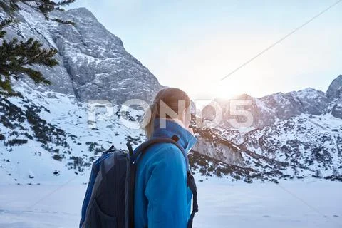 Young Woman Hiking In Snow And Watching The Sun On Mountain Top, Austria
