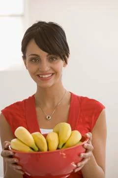 Young woman holding bowl of bananas Stock Photos