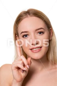 Young woman holding contact lens on index finger with copy space. Close up face Stock Photos