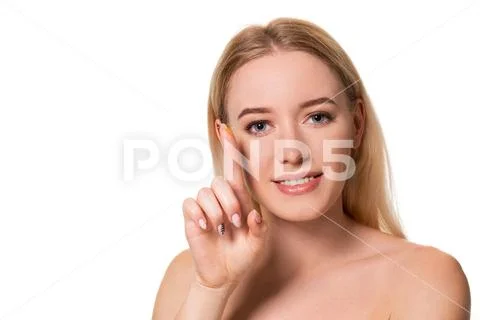 Young woman holding contact lens on index finger with copy space. Close up face Stock Photos